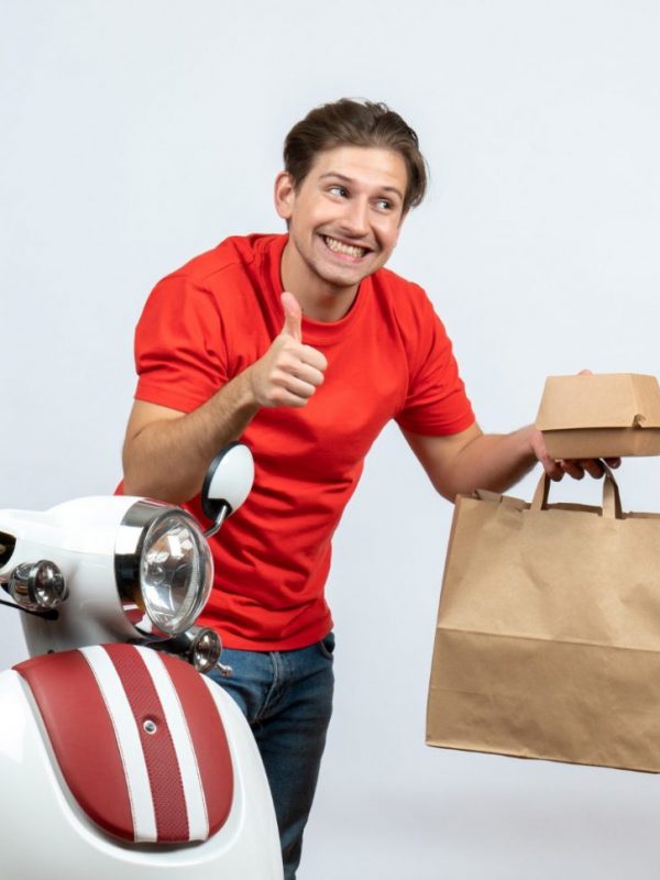 Smiling Delivery Man Red Uniform Standing Near Scooter Holding Bank Card Orders Making Ok Gesture White Background, Takeaway Times Magazine